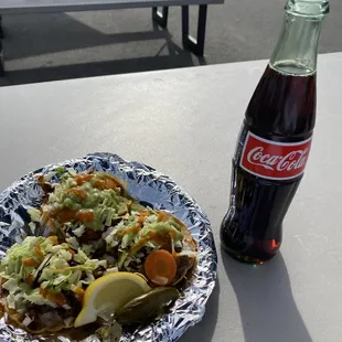 a bottle of coke and a plate of food