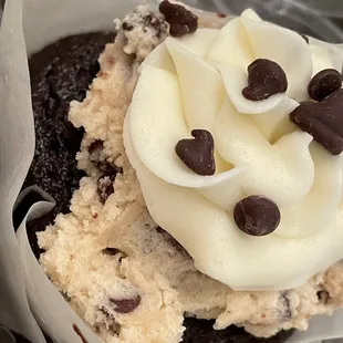 a cupcake with white frosting and chocolate chips