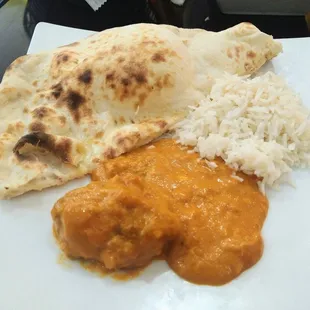 A piece of Malai Kofta, naan, and rice