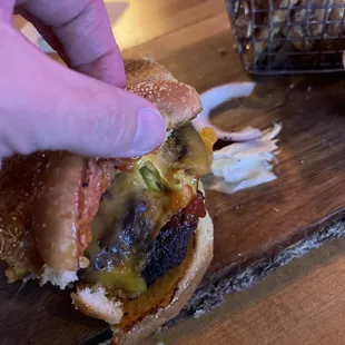 a hand holding a burger