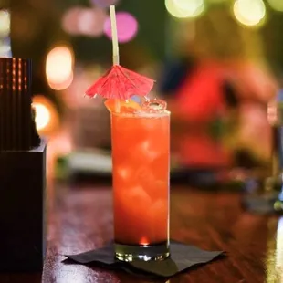 a cocktail with a red umbrella