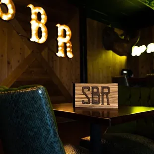 a wooden table and green chairs