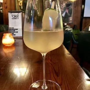 a glass of white wine on a bar