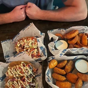 a man sitting at a table with three trays of food