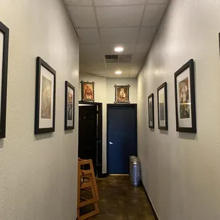a long hallway with framed art