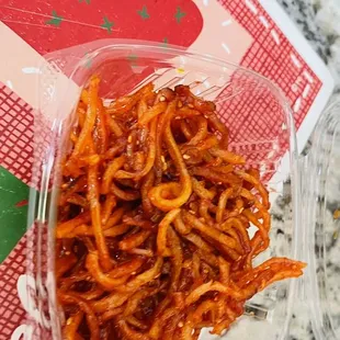 a plastic container of spaghetti