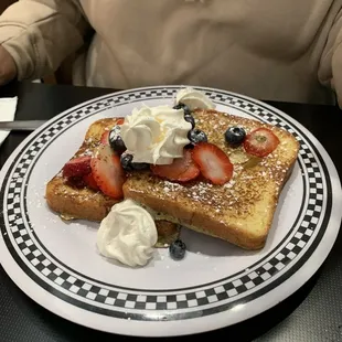 French toast with blueberries, strawberries and whipped cream
