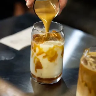 a person pouring caramel into a glass