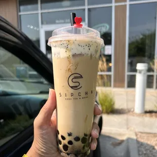 a hand holding a cup of iced coffee