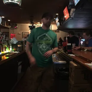 ows a man standing at a bar