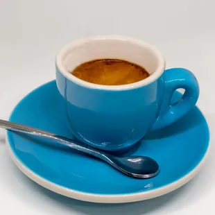 ows a cup of coffee on a saucer with a spoon