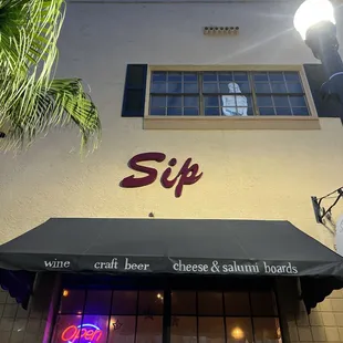 the outside of a restaurant with a neon sign