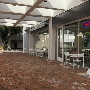 a brick patio with tables and chairs