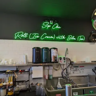 a neon sign above a kitchen counter