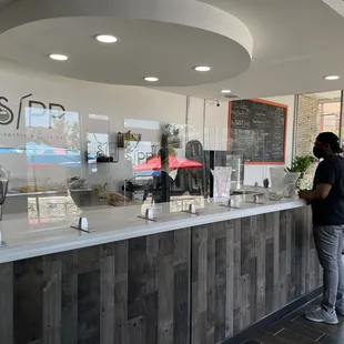 a man standing at the counter of a coffee shop