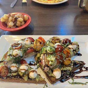 Special of avacado toast with mozzarella pearls and tomato&apos;s drizzled with balsamic glaze