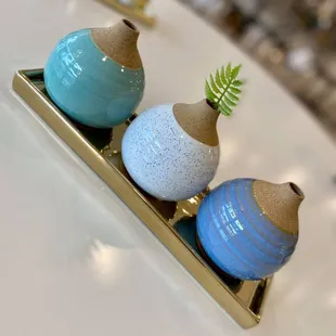 three ceramic vases on a tray