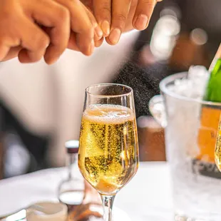 champagne being poured into two glasses