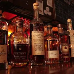bottles of whiskey lined up on a bar
