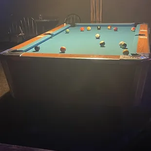 a pool table in a dimly lit room
