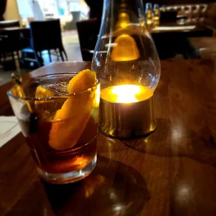 a glass of whiskey and a candle