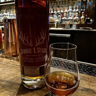 a glass of whiskey and a bottle of liquor