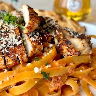 Blackened Chicken Pasta with cherry peppers, fresh basil, spicy tomato cream, parmesan and fettuccini