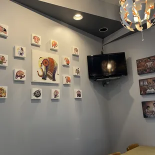 a dining room with a television and pictures on the wall
