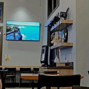 a man sitting at a table in front of a flat screen tv