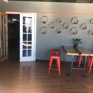 a room with a table and red stools