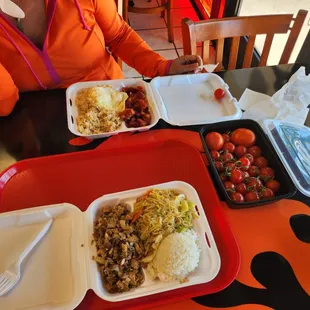 a woman sitting at a table with plates of food