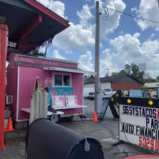 a mailbox in front of a pink building