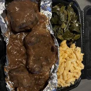 Oxtail plate with greens and macaroni and cheese.