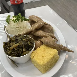 Smothered chicken with greens and mashed potatoes and corn bread