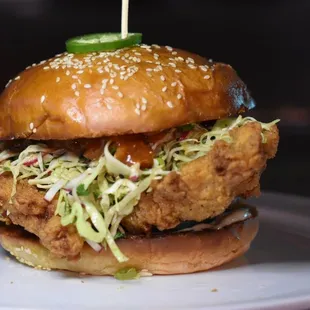 a fried chicken sandwich with coleslaw and pick