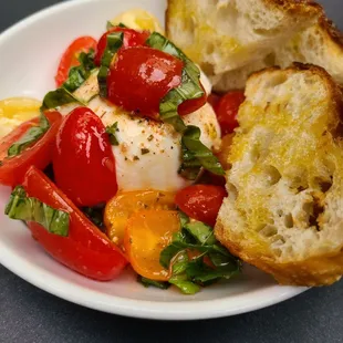 a plate of food with bread and tomatoes