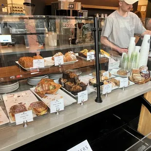 a man standing in front of a bakery counter
