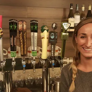  woman standing in front of a row of beer taps