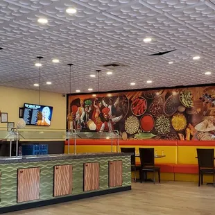 a restaurant with a large mural on the wall