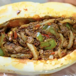 **Cumin Beef RouJiaMo** (Spicy) 
   *Stir-fried cumin beef with onions and chilies, served in a crispy, layered flatbread.*