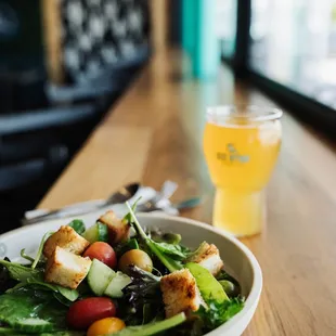 a bowl of salad and a glass of beer