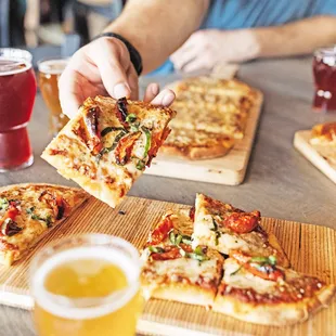 a person taking a slice of pizza
