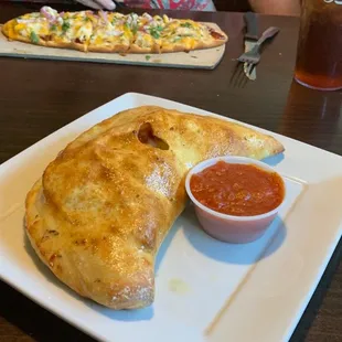 A lovely calzone in the foreground and flatbread in the background.