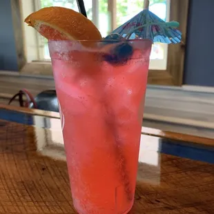 a pink drink with a blue umbrella