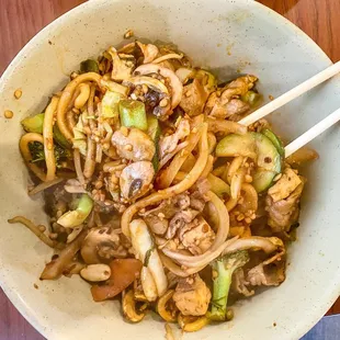 a bowl of noodles with chopsticks