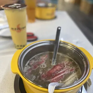 a hot pot with hot dogs in it