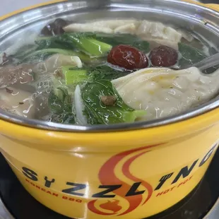 Herb broth loaded with veggies, dumplings, beef balls, mini sausages, and some rolled meats.