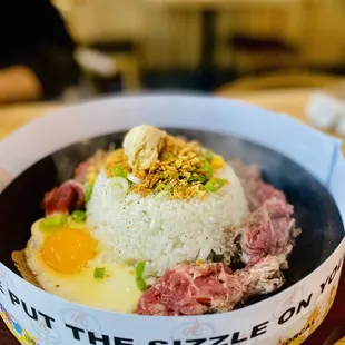 a bowl of rice with meat and eggs