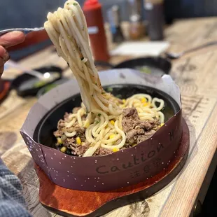 a bowl of noodles being held by a person