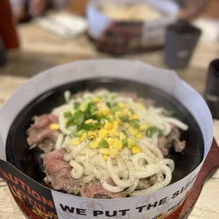 a bowl of noodles with meat and vegetables